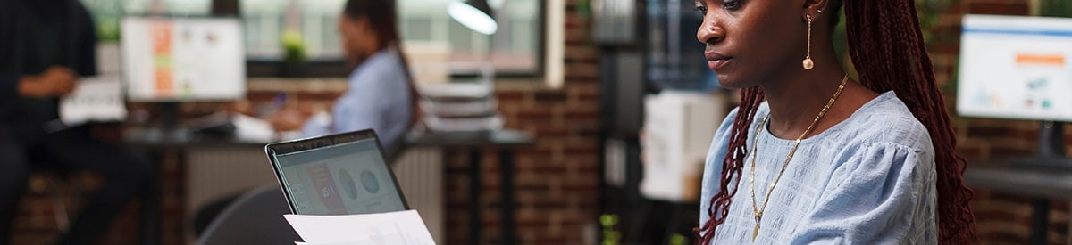 一位女士坐在办公室的办公桌前批阅文件