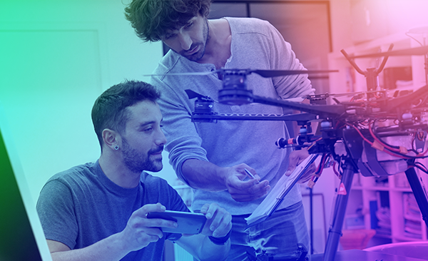 A drone is being worked on by two student engineers.